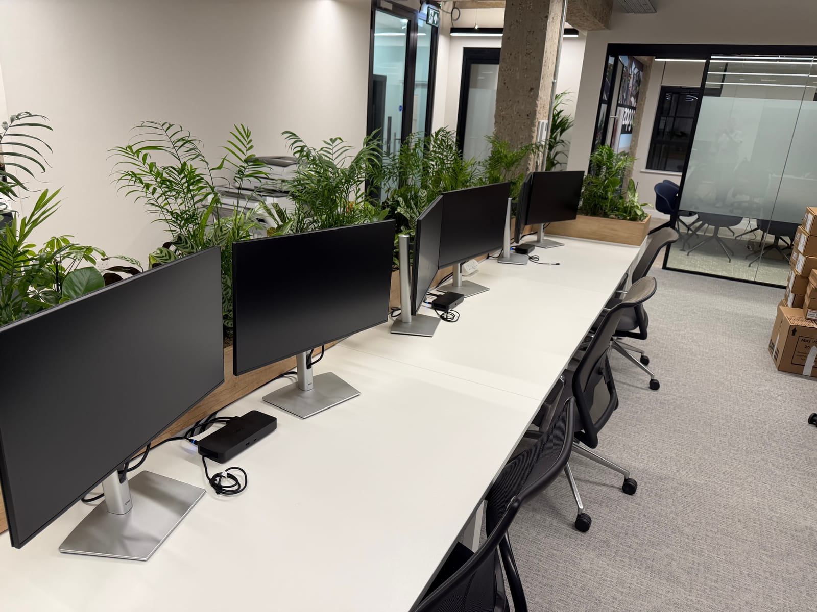 Completed desk setups with dual monitors and docking stations.